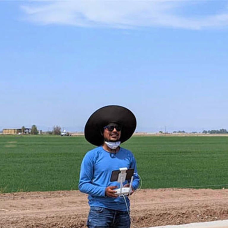 Haghverdi Lab student flying a drone in a field