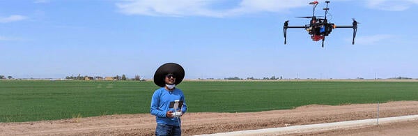 Haghverdi Lab student flying a drone in a field