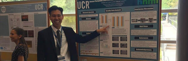 RISE participant in front of research poster